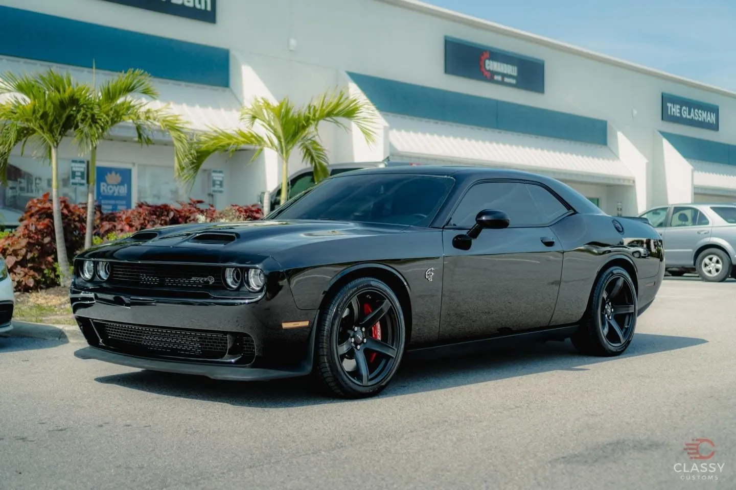 Black Dodge Challenger with blacked-out trim outside the shop