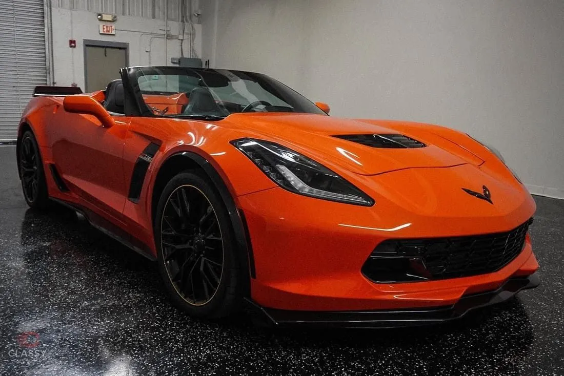 Orange Chevrolet Corvette convertible with glossy paint in the shop