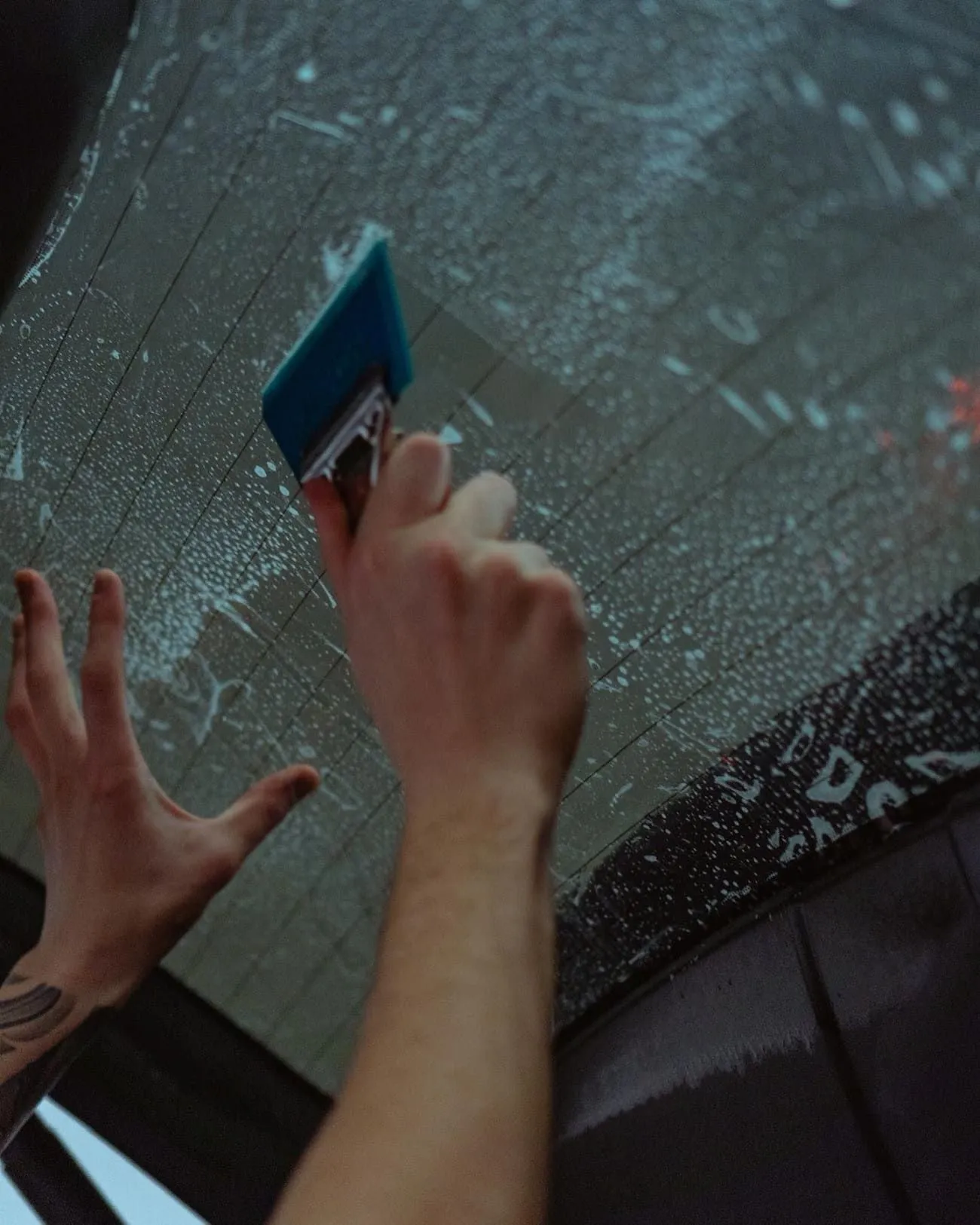 Squeegee on wet glass during a window tint install