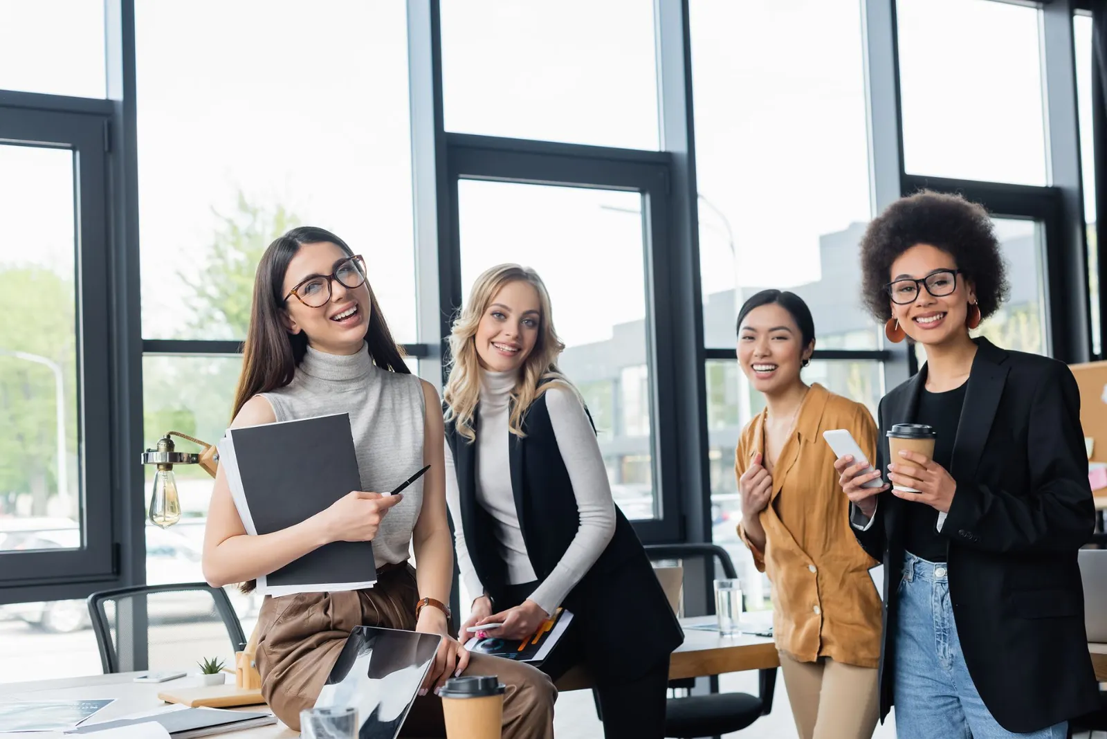 Group of coworkers in an office with floor-to-ceiling glass