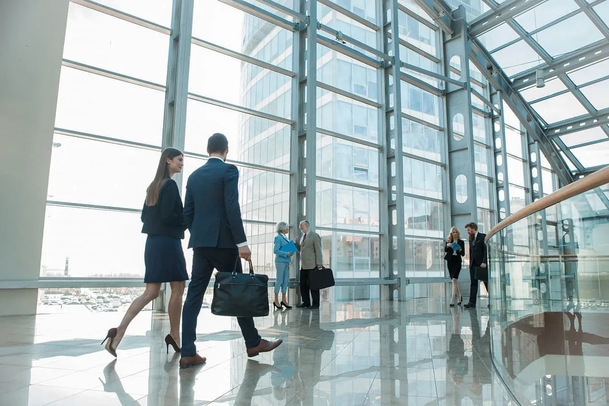People walking through a glass-walled atrium