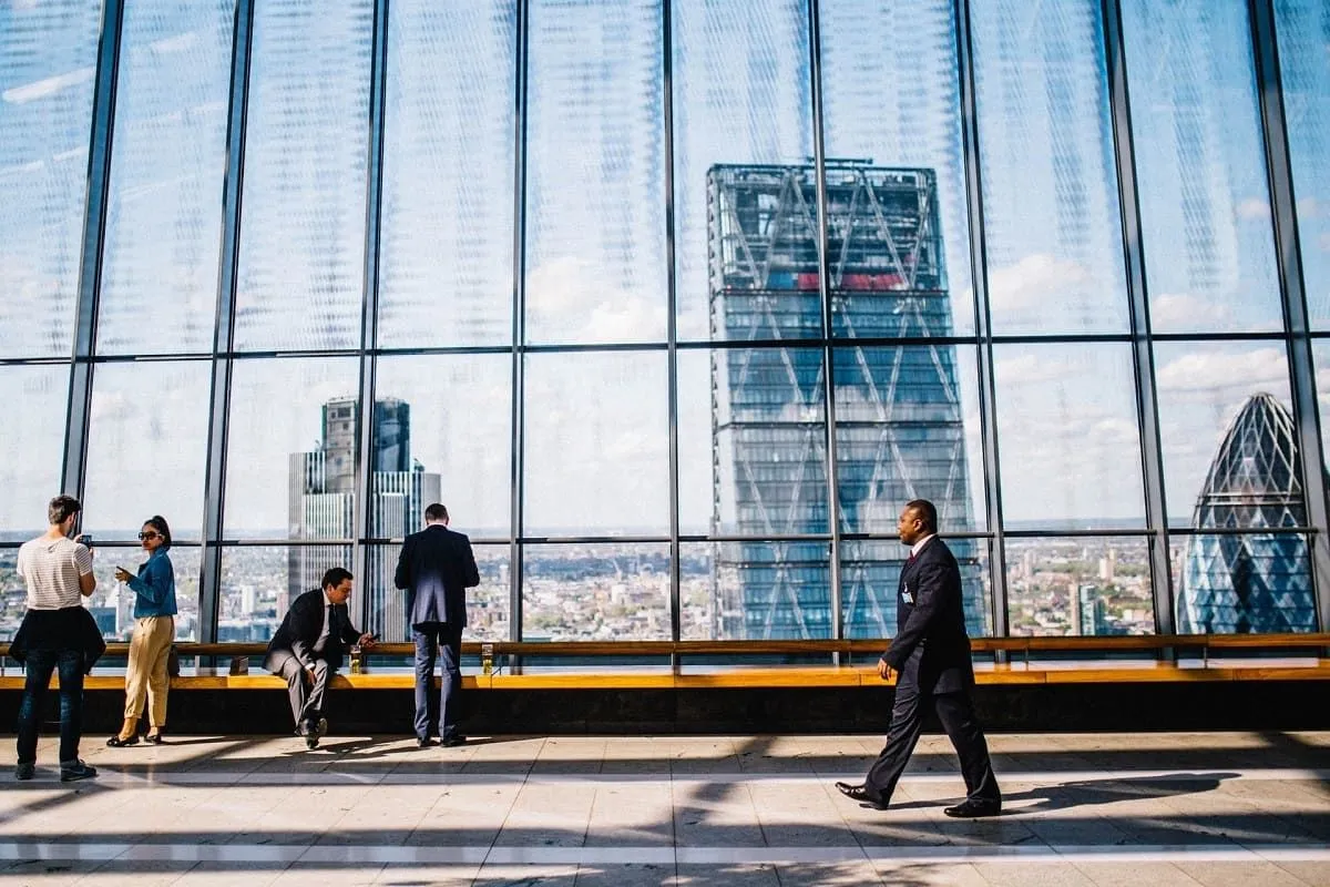 People walking past a floor-to-ceiling window wall