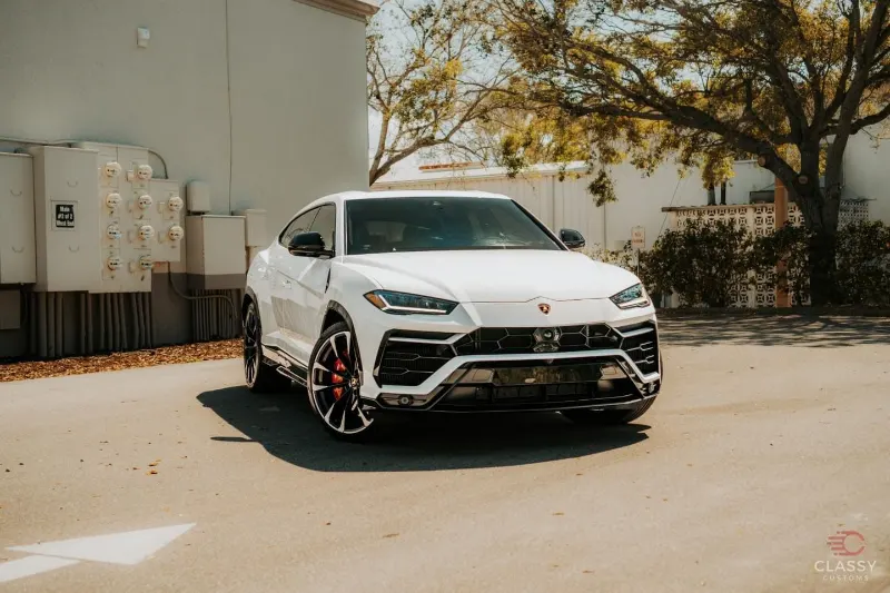 White Lamborghini Urus parked outside at golden hour