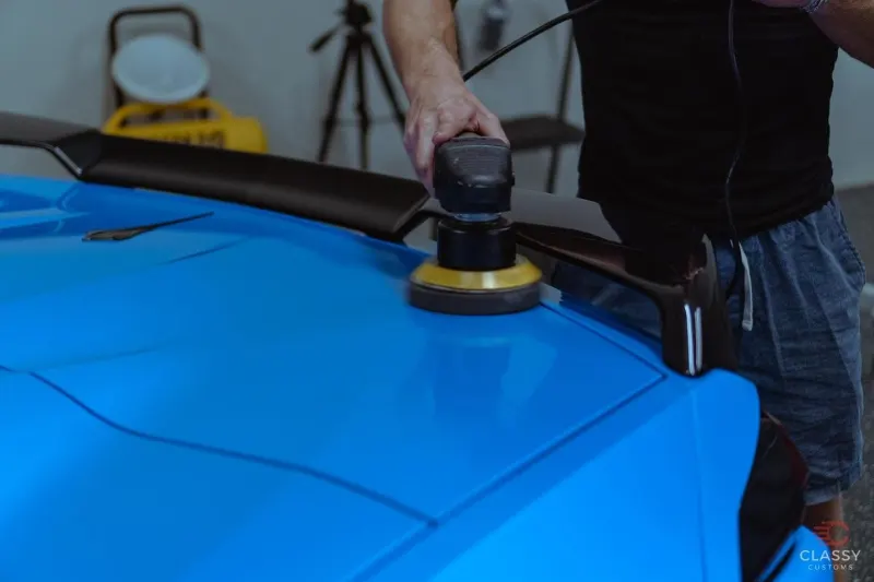 Machine polishing the paint on a blue car