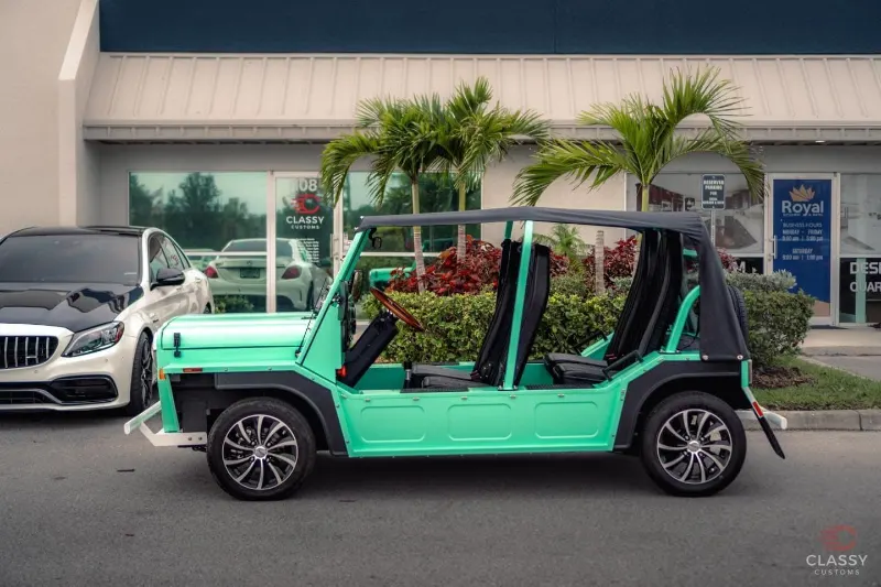 Mint green Moke in front of the shop