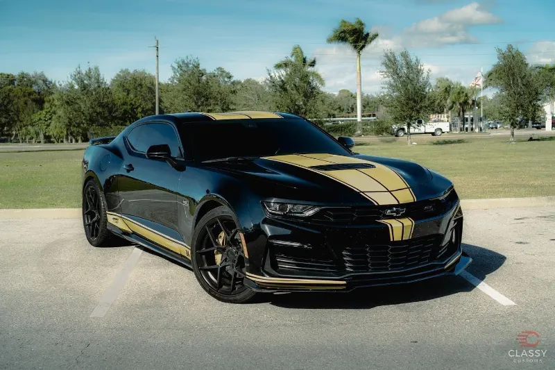 Black Chevrolet Camaro with gold stripes