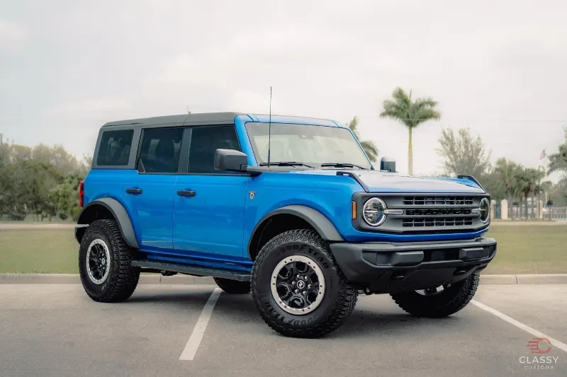 Blue Ford Bronco with black wheels