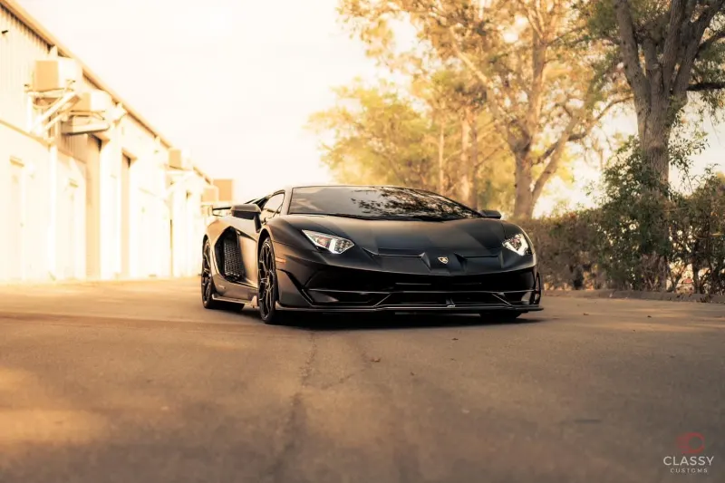 Black Lamborghini Aventador parked at golden hour