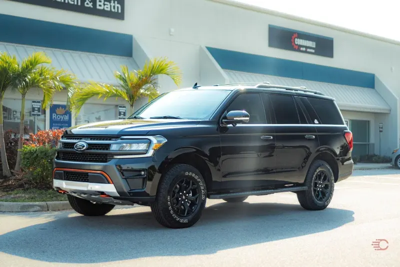 Black full-size SUV parked in front of the Classy Customs shop