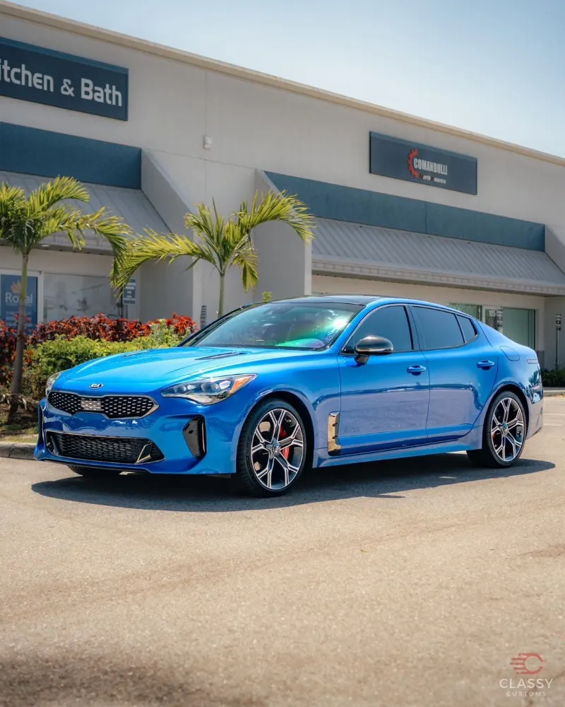 Blue Kia Stinger in front of the shop
