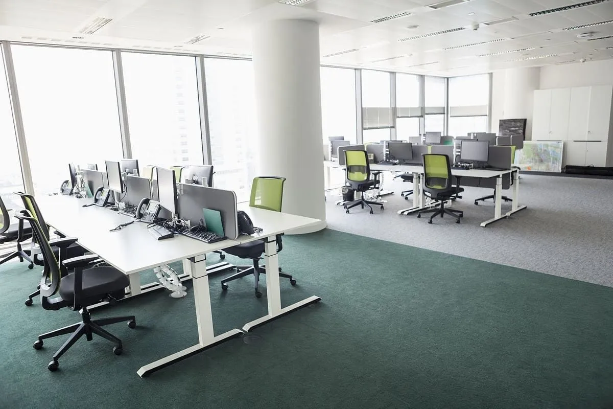 Open office with workstations beside large windows