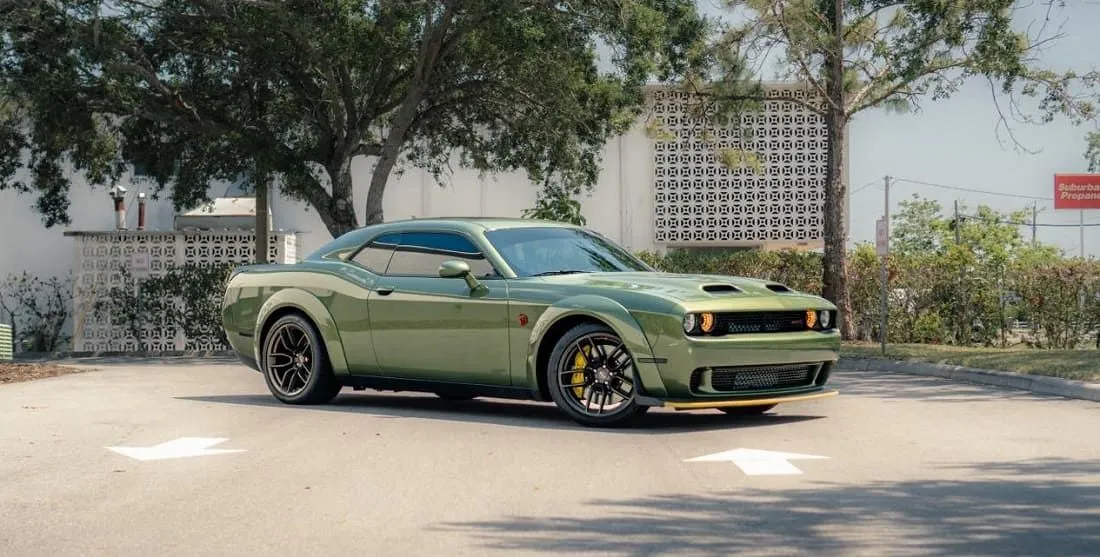 Green Dodge Challenger in front of the shop